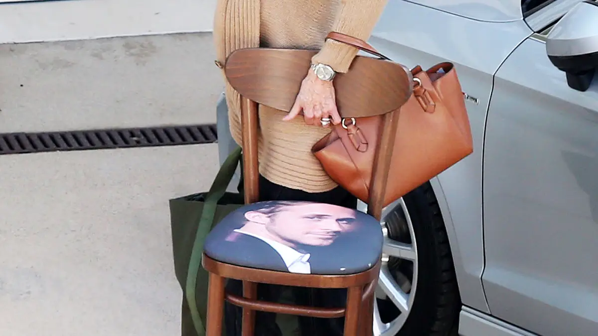 Jane Fonda carries a chair with Ryan Gosling's face on it