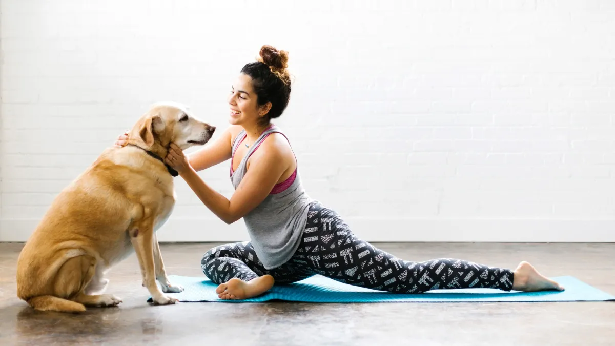 Woman practicing yoga with dog