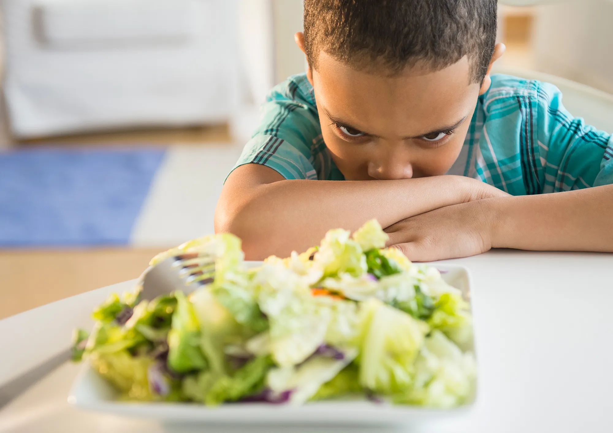 boy refusing to eat salad