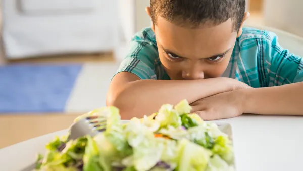 boy refusing to eat salad