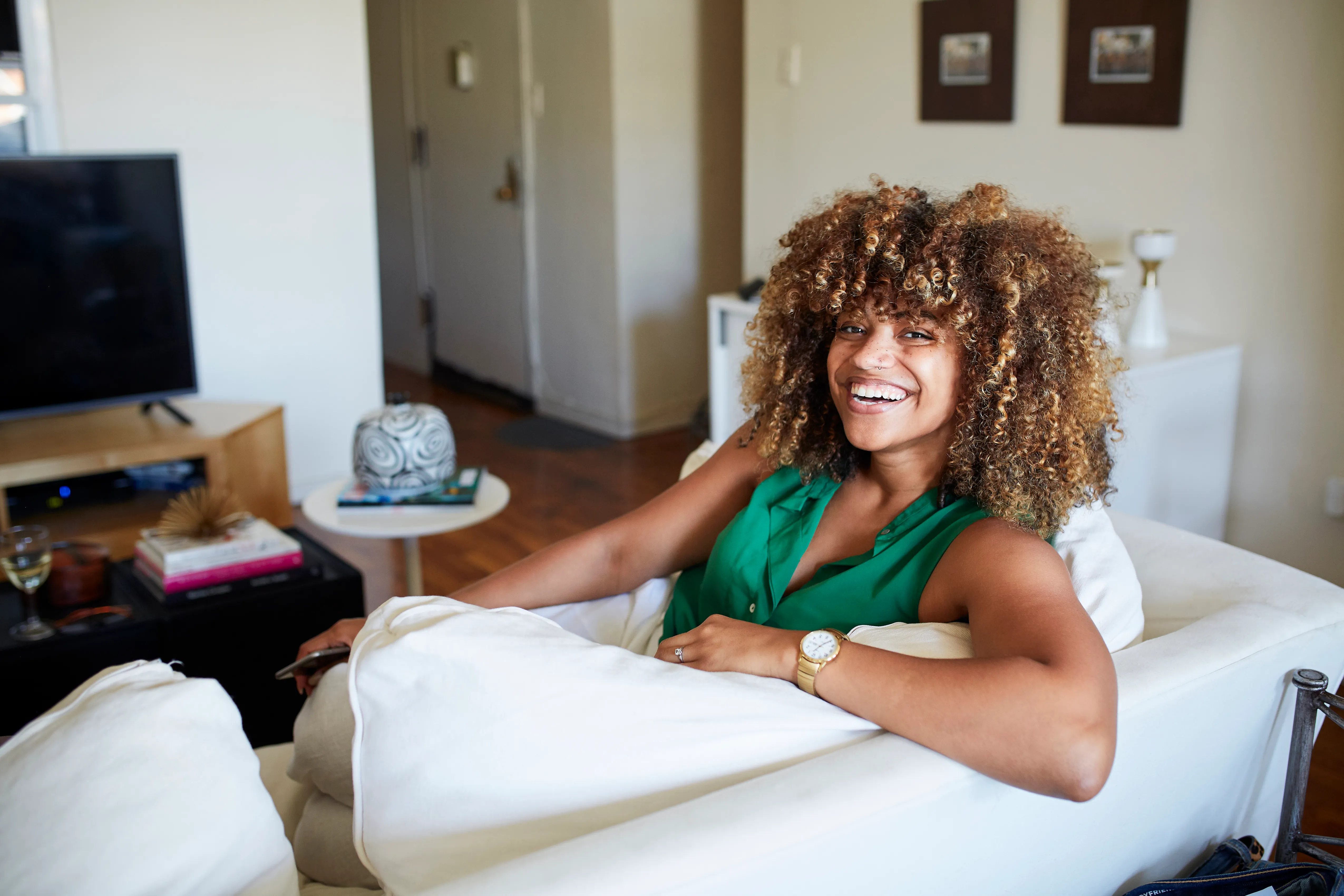 Portrait of smiling Black woman sitting on sofa