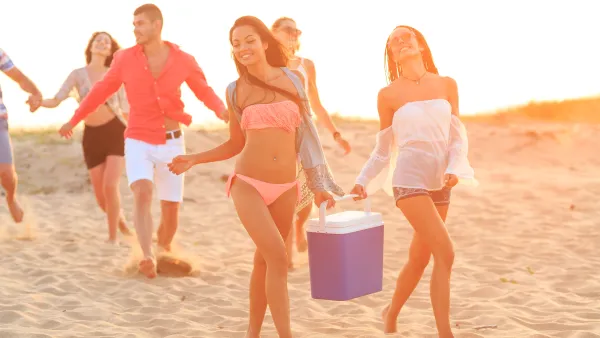 people at beach with cooler
