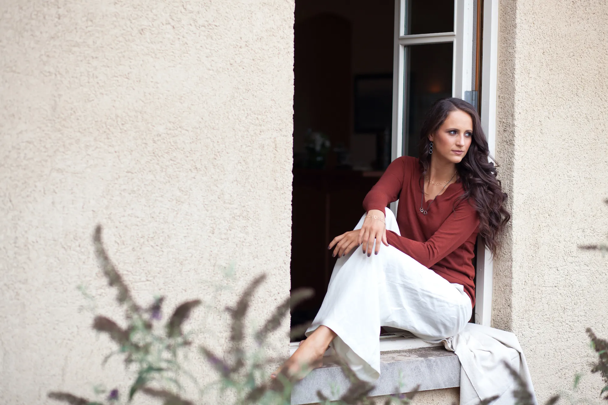 Young woman sitting in windowsill