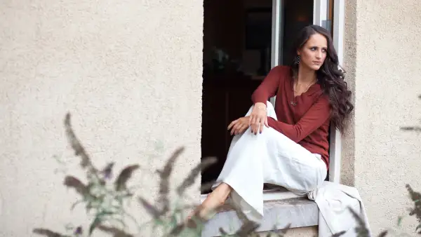 Young woman sitting in windowsill