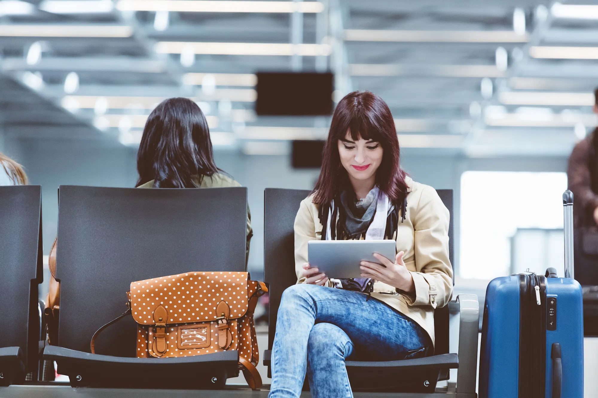 Young woman using tablet pc at airport
