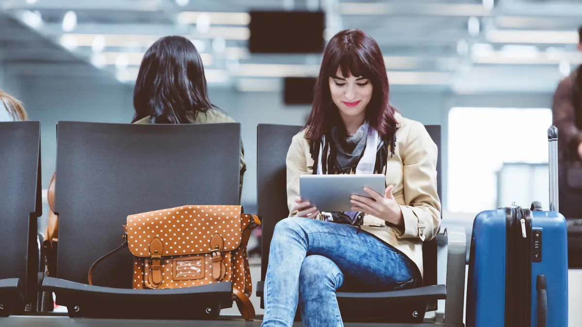 Young woman using tablet pc at airport