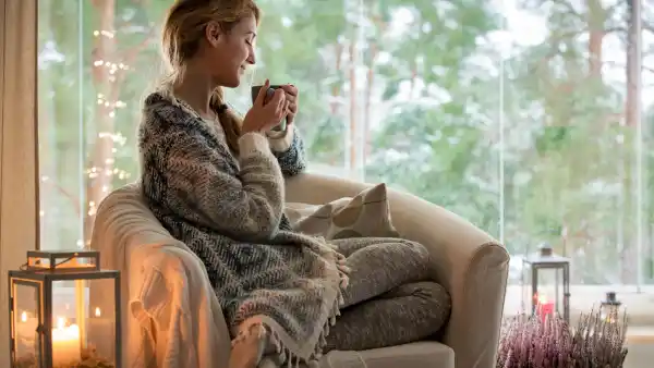 Young woman sitting home by the window