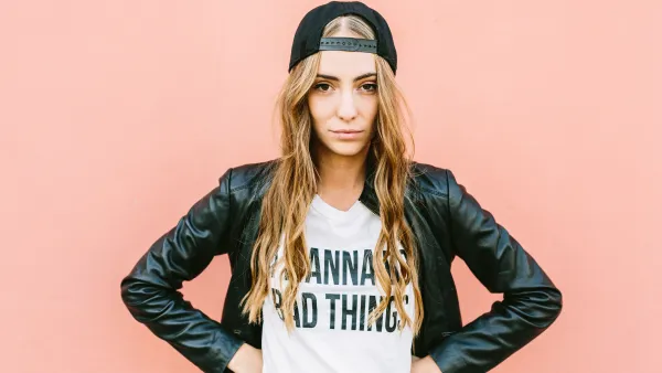 Portrait of fashionable young woman wearing black baseball cap and leather jacket