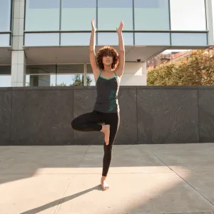Young woman doing a tree pose on the pavement