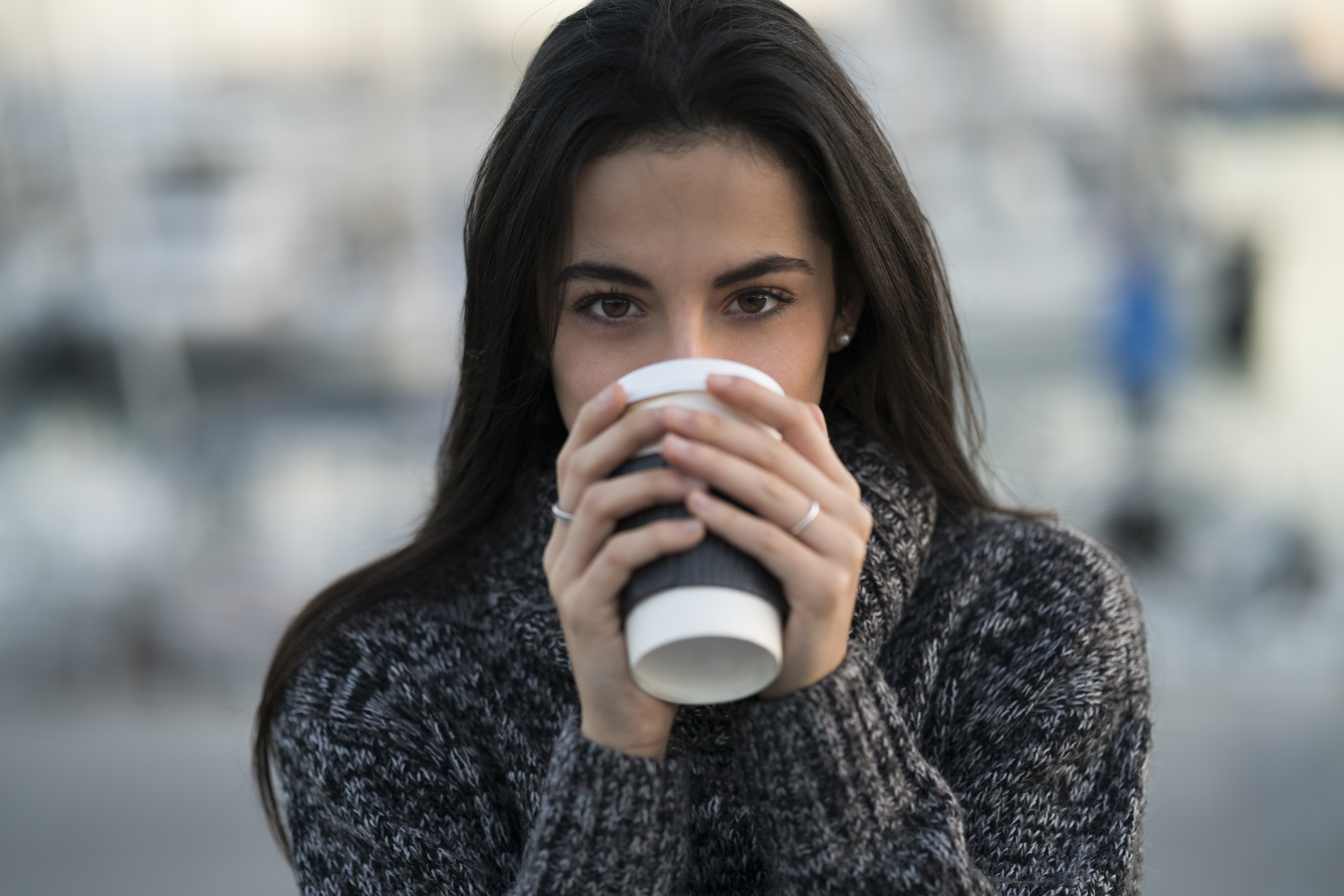 woman drinking from coffee cup in sweater