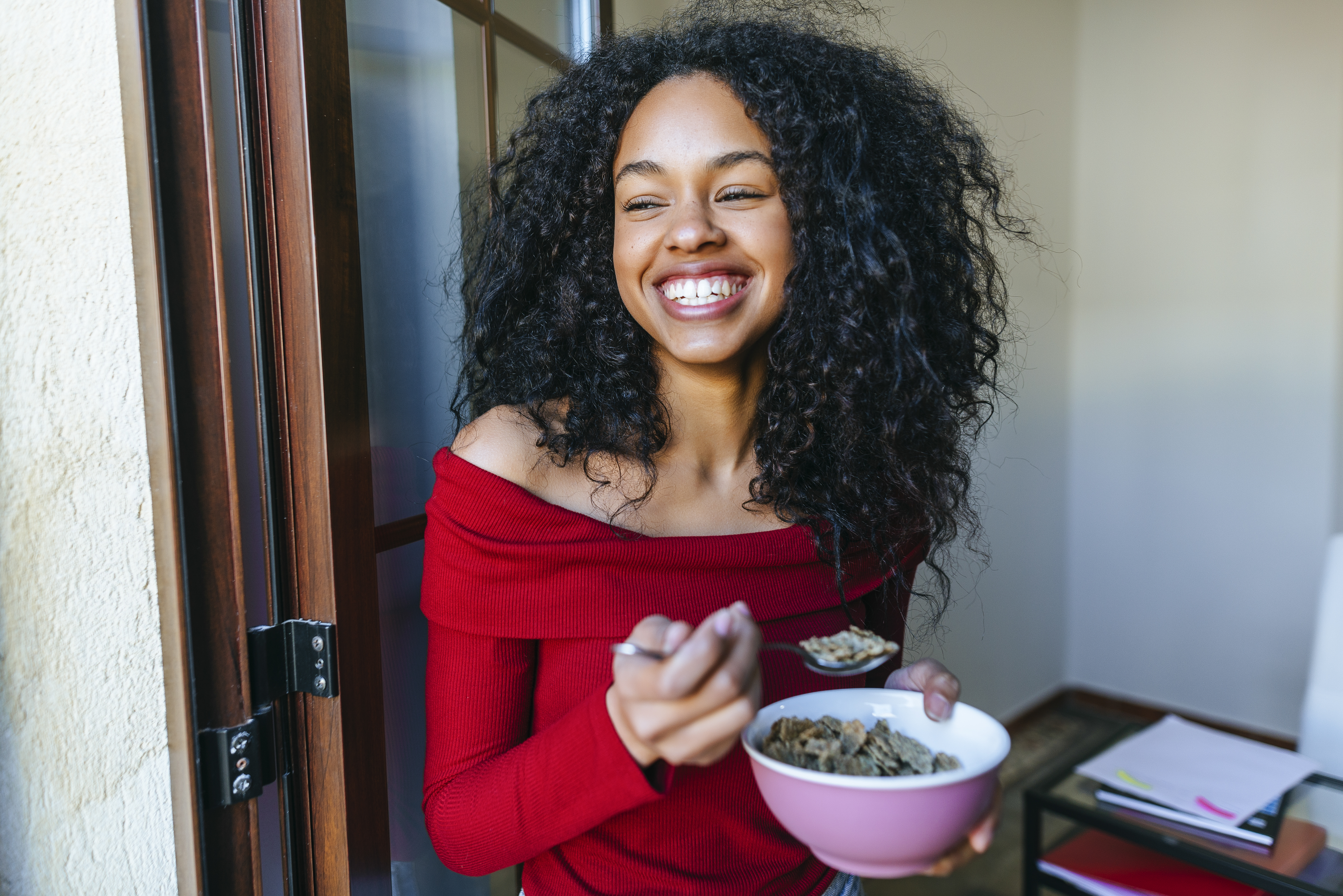 woman smiling and eating cereal