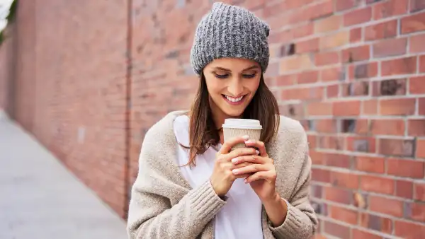 Happy woman with coffee to go