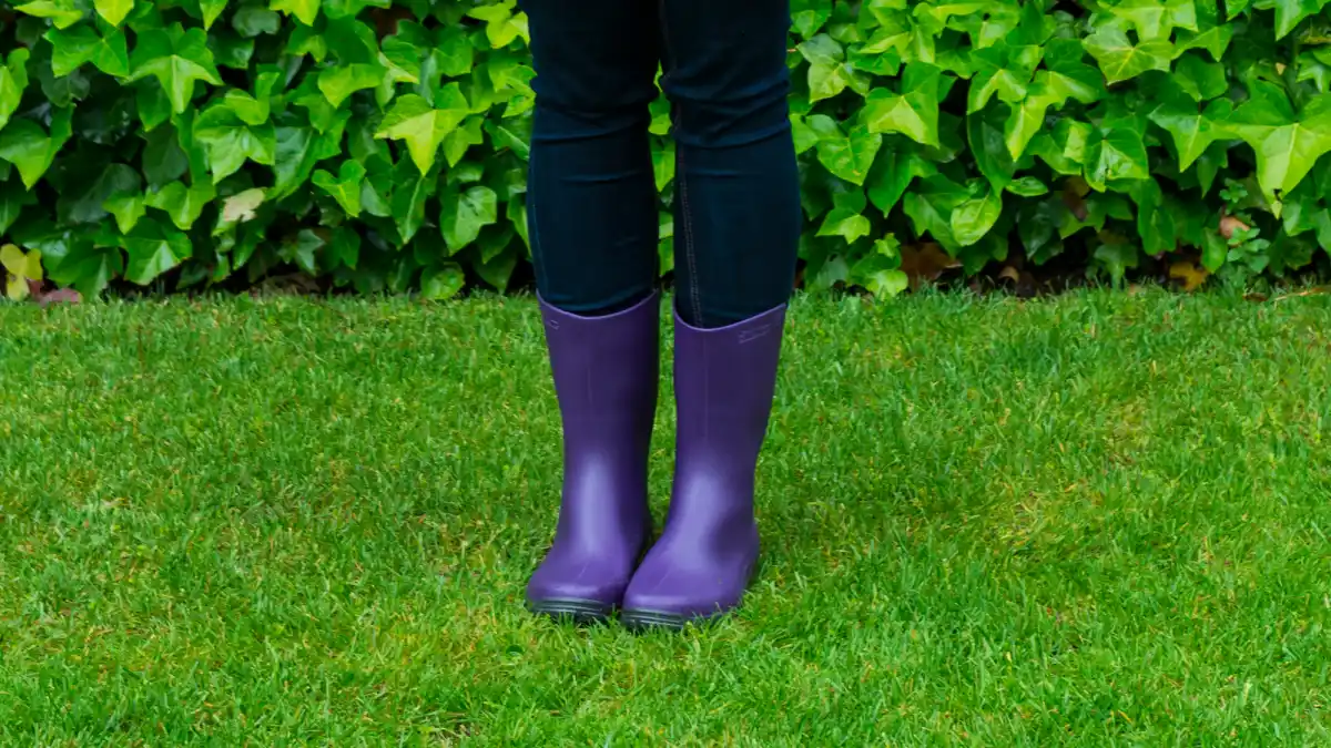 Young woman with playing with a colorful umbrella in a rainy day.