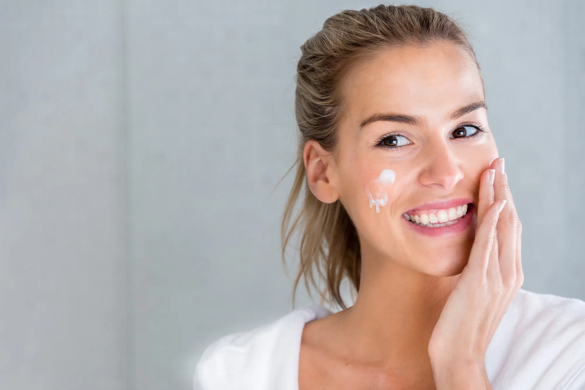 Beauty portrait of a woman using moisturising cream