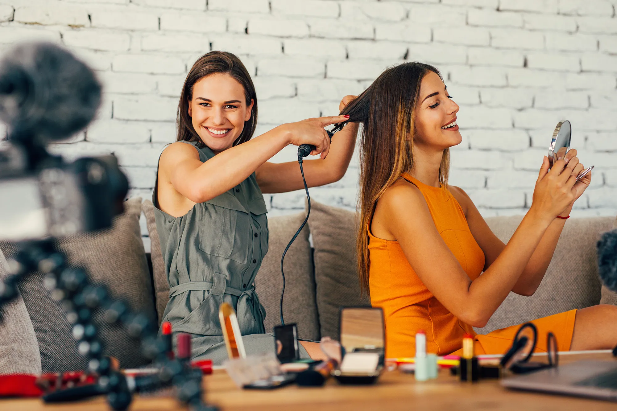 Two women doing a hairdo vlog at home.