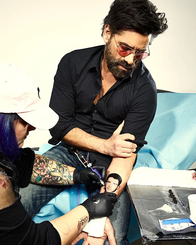 John Stamos Ups His Prank War With Nick Jonas By Tattooing His Face On His Arm