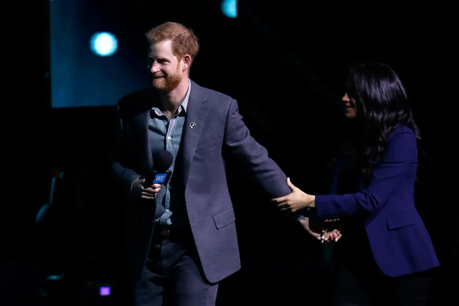 Prince Harry Surprises Crowd and Drags Pregnant Wife Duchess Meghan on Stage at Charity Event