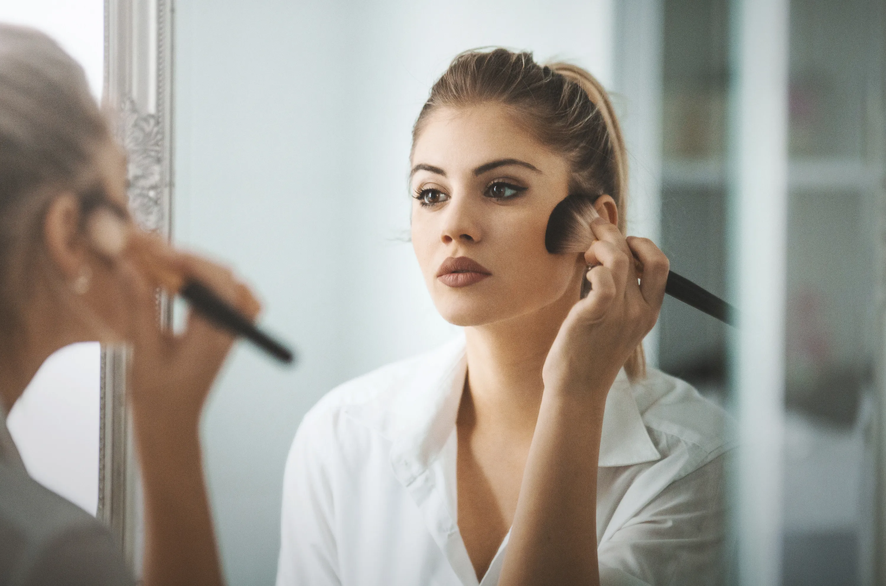 woman putting on makeup