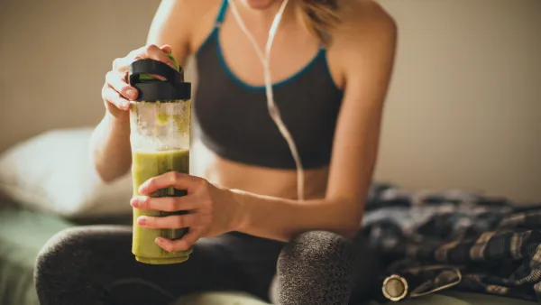Young woman getting having her green smoothie after training