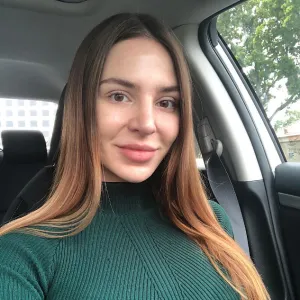 Anfisa Nava Sitting In Her Car Wearing A Green Shirt