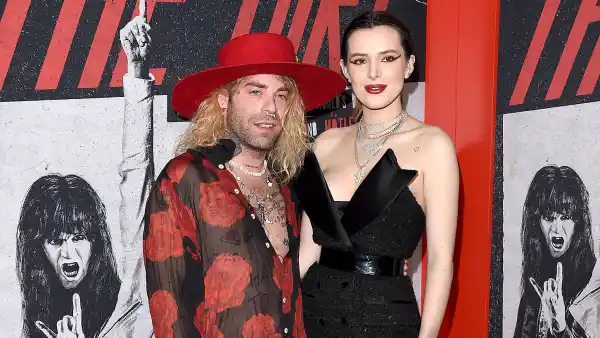 Mod Sun Wearing Black Leather Pants and Red Shirt with Red Brim Hat and Bella Thorne Wearing Black Dress