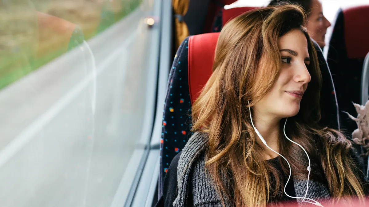 A young woman travelling with bus while listening music