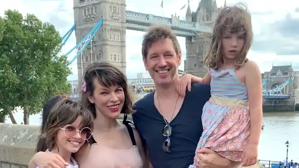 Milla-Jovovich-Cradles-Growing-Baby-Bump-in-Sweet-Family-Pic-With-Husband-and-Daughters