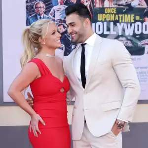 Sam-Asghari-Cooks-Steak-For-Britney-Spears Red Dress White Suit Black Tie Looking At Each Other