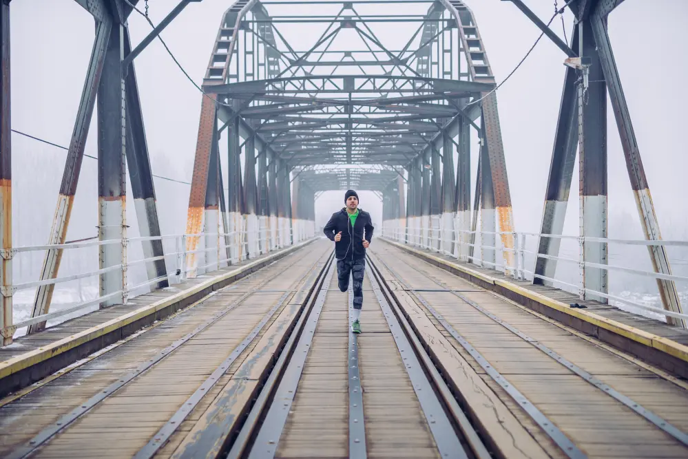 Shot of a male running on the train bridge.