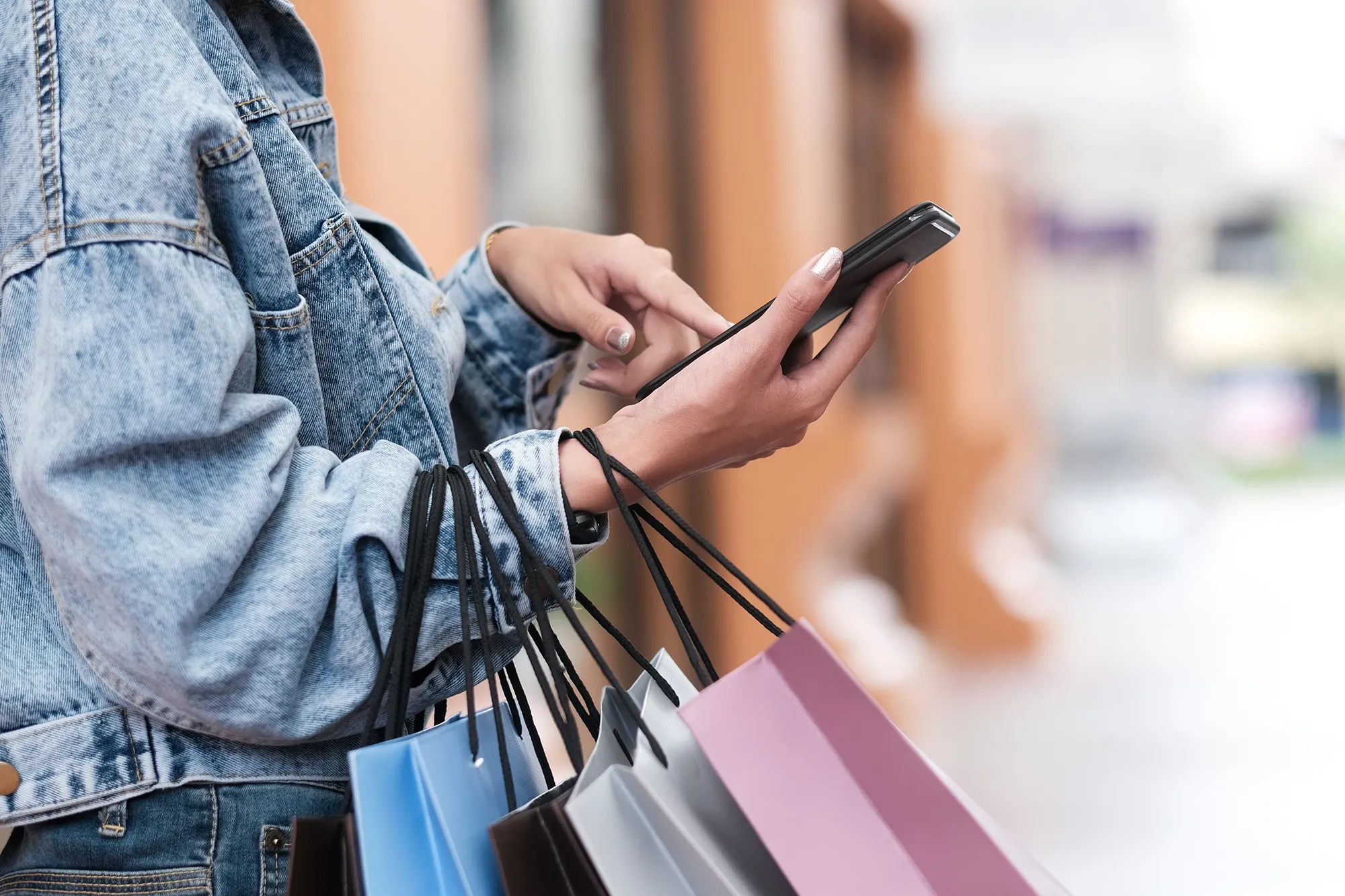 Closeup woman hand using mobile phone in shopping checking sales promotion.