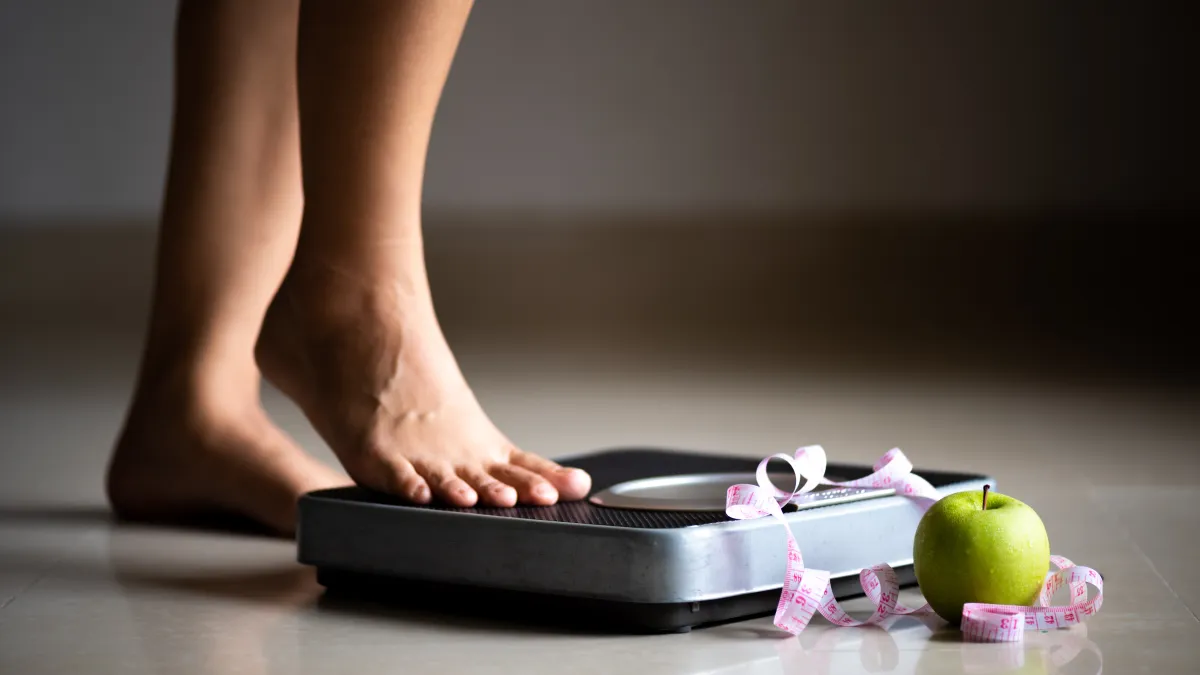 woman stepping on scale