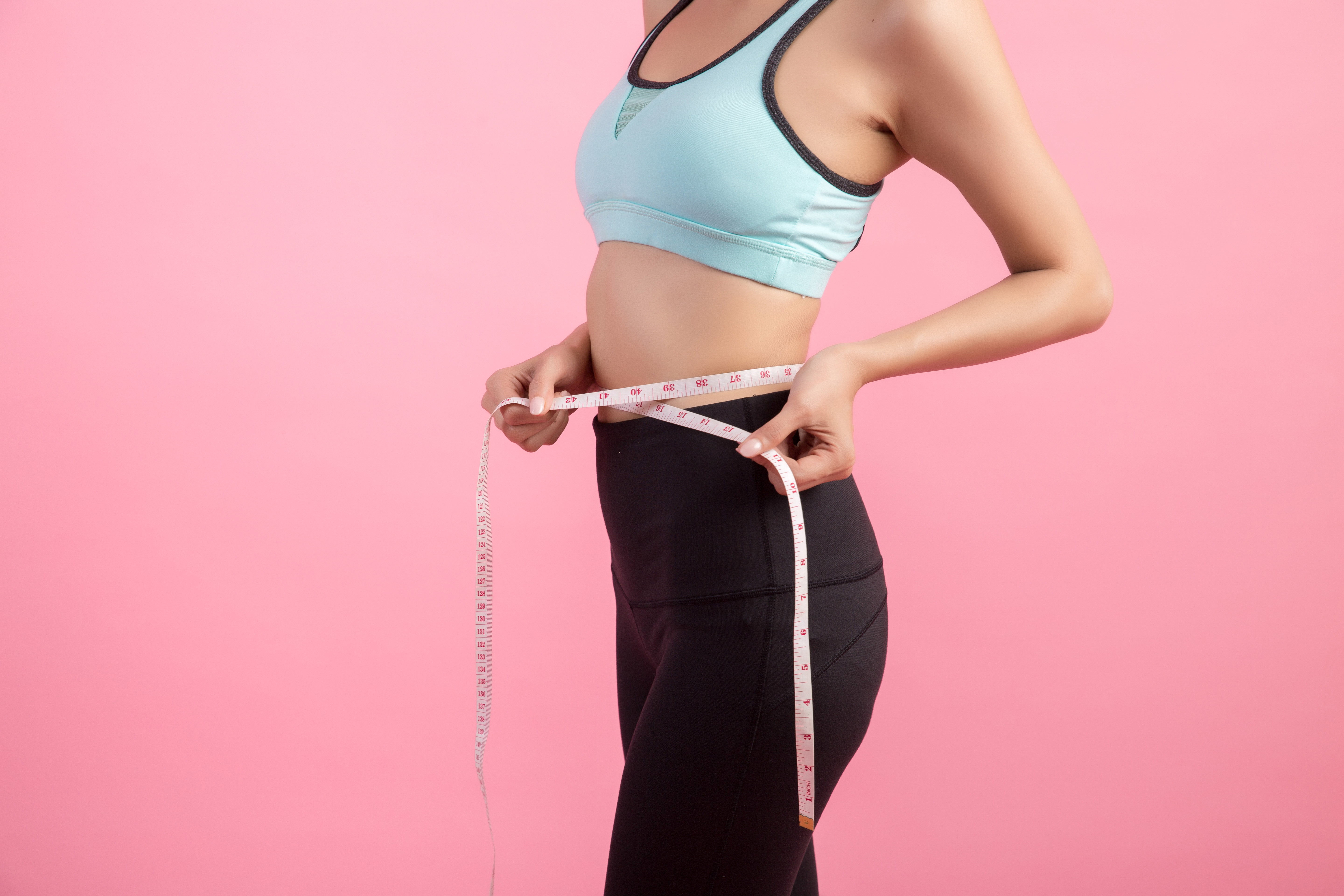 woman taking waist measurement