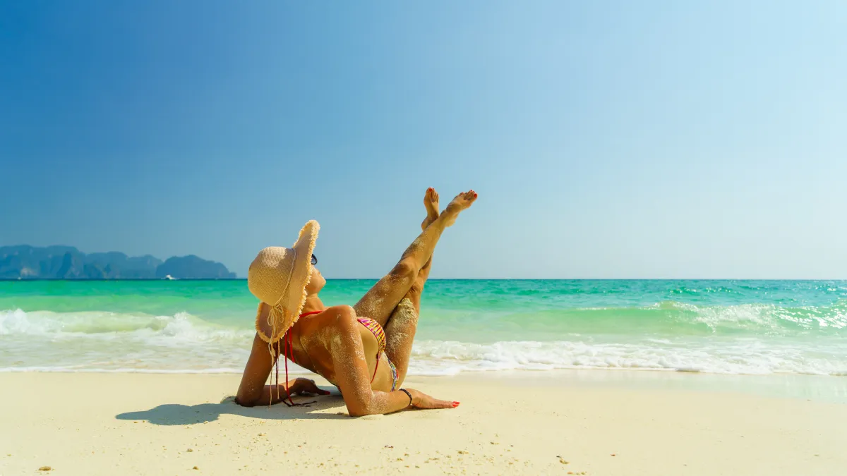 woman sunbathing on the beach stock photo