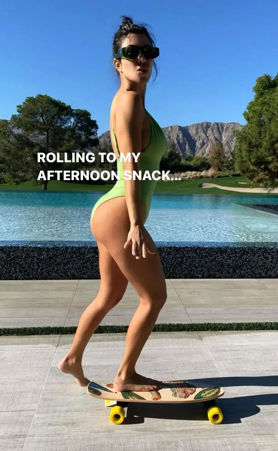 Kourtney Kardashian Skateboards Poolside in a Green Swimsuit