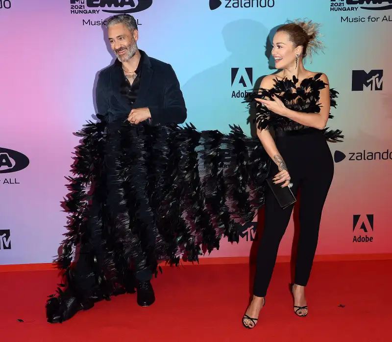 To the Rescue Taika Waititi Fixes Girlfriend Rita Ora’s Dress on 2021 EMAs Red Carpet