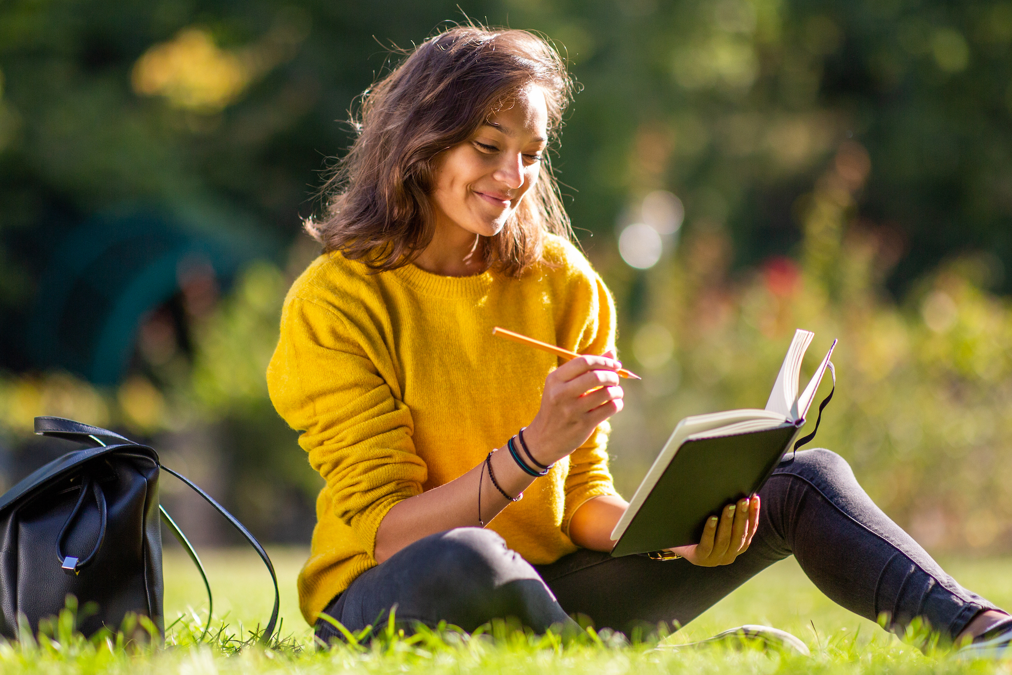 Woman-Journaling-In-The-Park-Stock-Photo