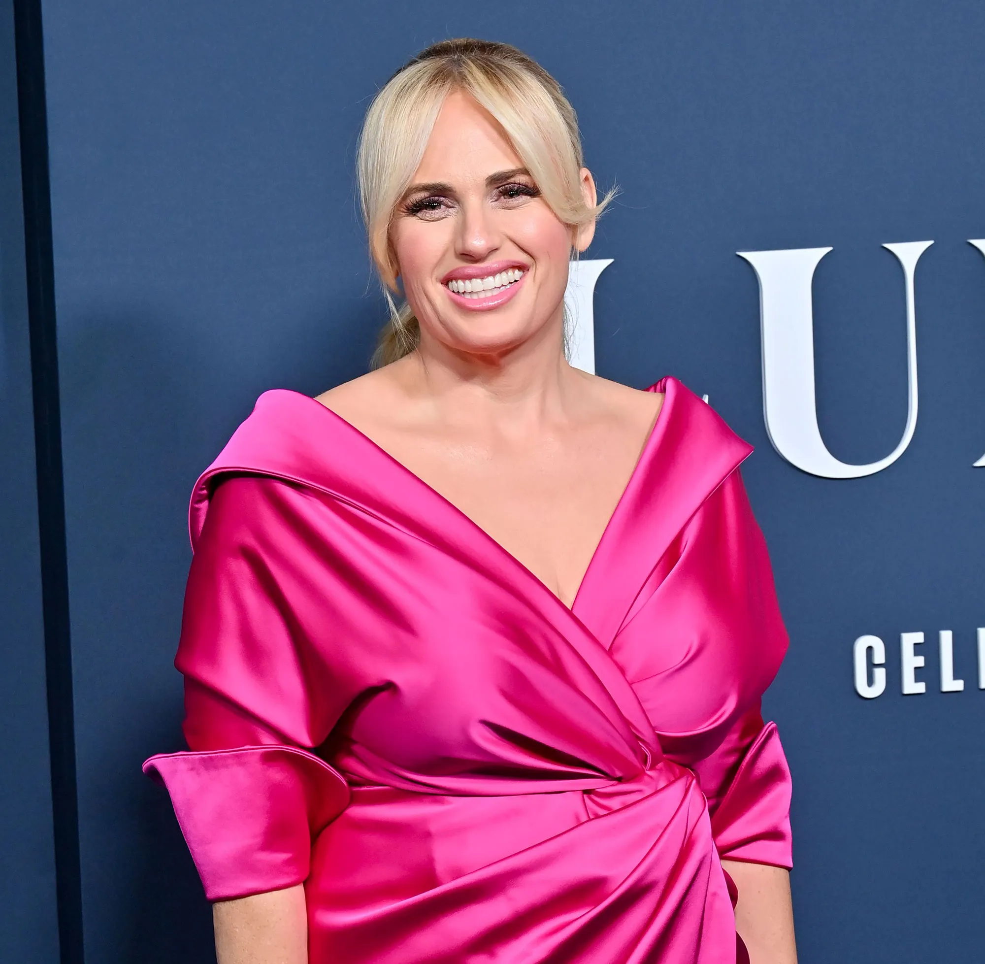 Rebel Wilson Opens Up About 1st Kiss With A Woman: Lesbian Scene ‘Changed My Love Life Completely’ hot pink satin gown