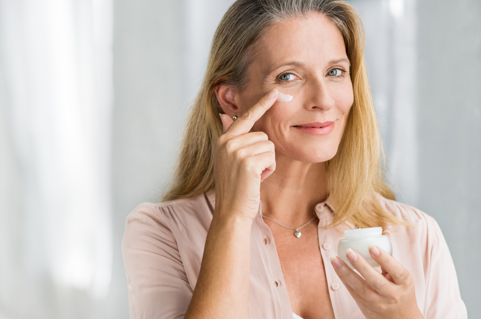 Mature-Woman-Applying-Moisturizer-Stock-Photo