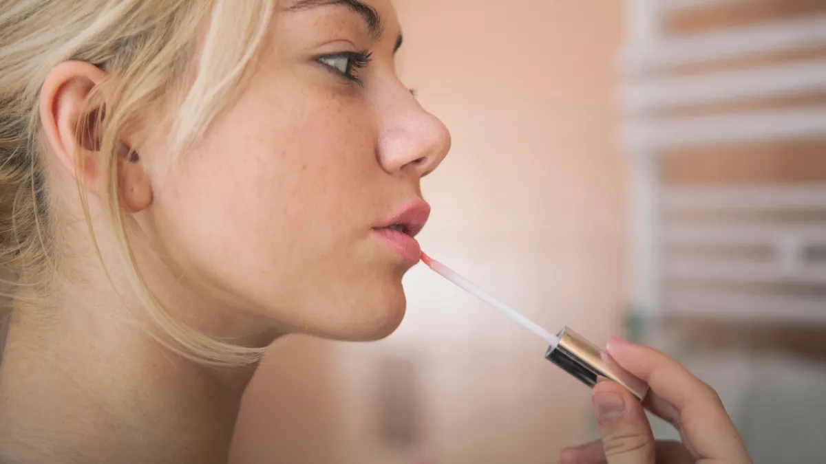 Woman-Applying-Lip-Gloss-Stock-Photo