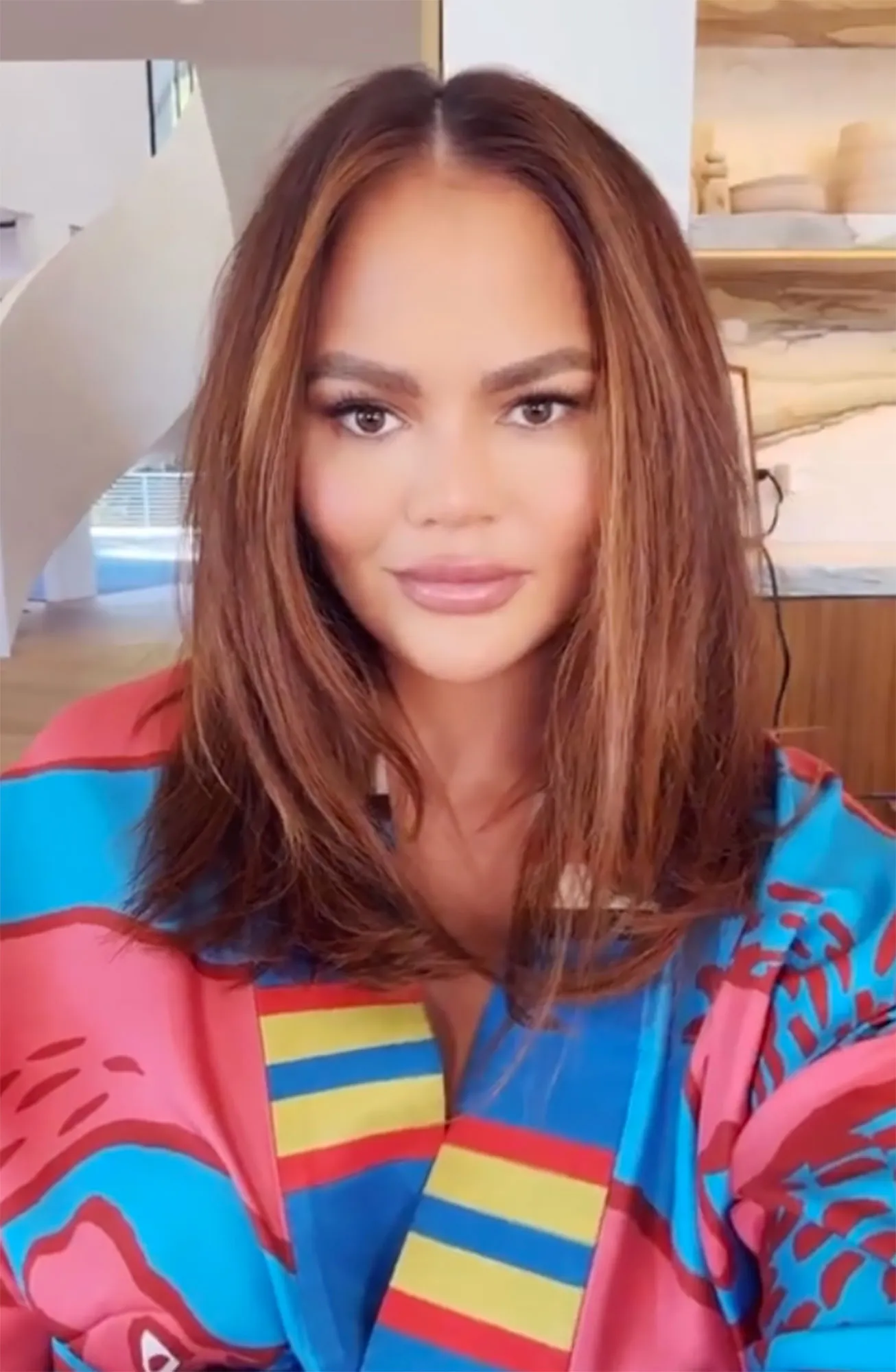 Chrissy Teigen Debuts New Hair Color pink blue robe