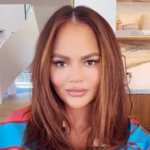 Chrissy Teigen Debuts New Hair Color pink blue robe