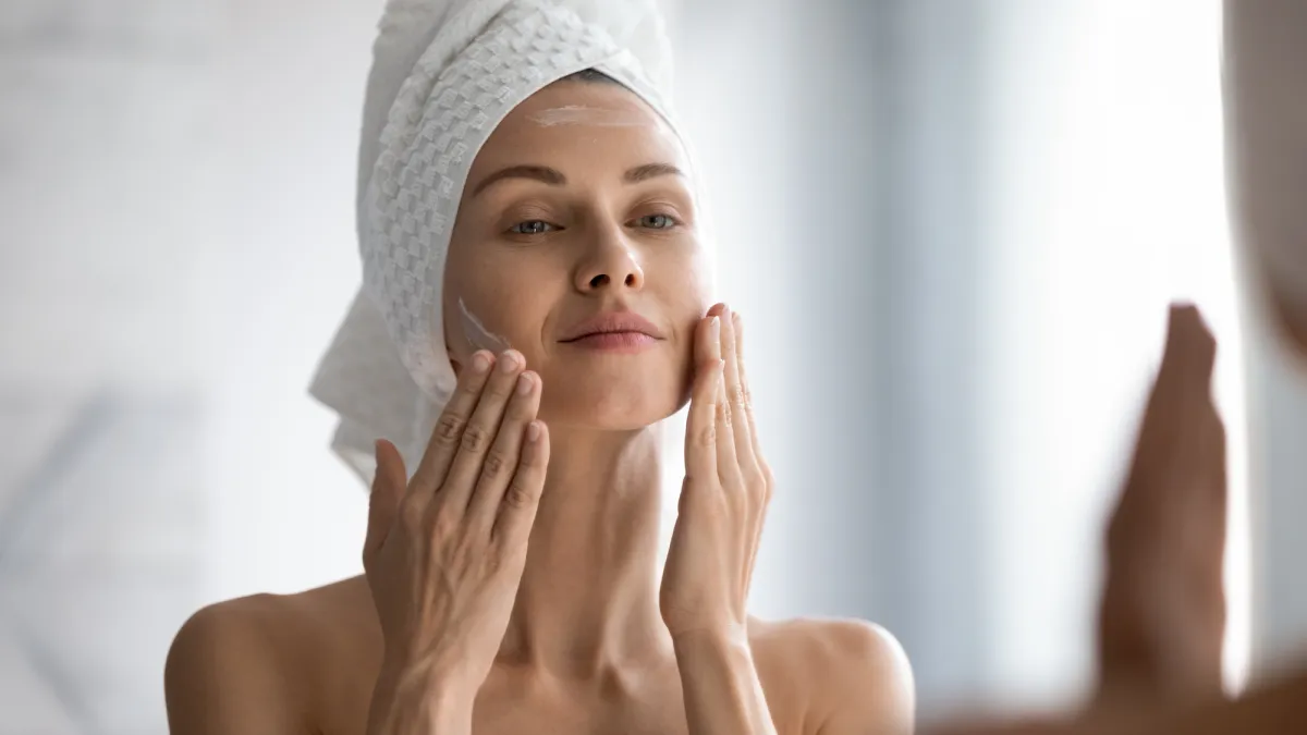 Woman-Applying-Moisturizer-Stock-Photo