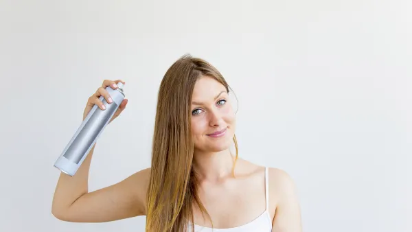 Woman-Spraying-Dry-Shampoo-Stock-Photo