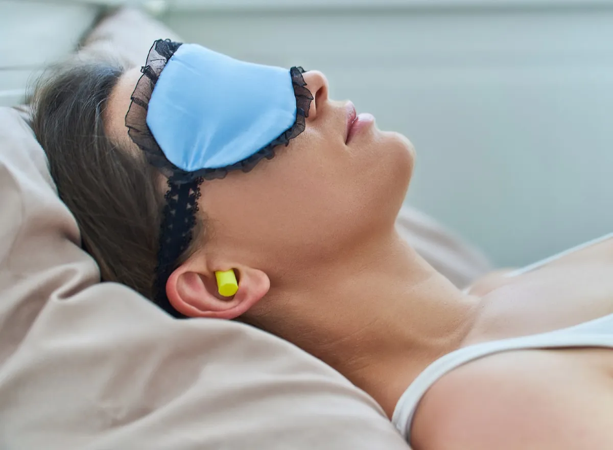 Woman sleeping with earplugs in her ears