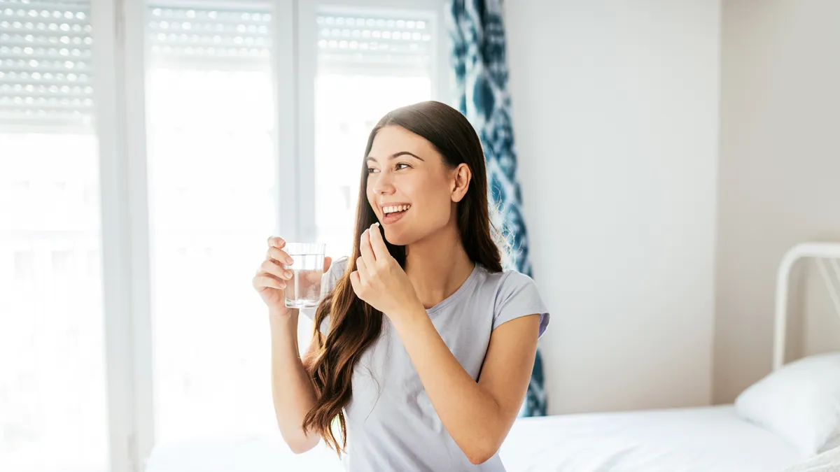 Healthy young woman taking supplements