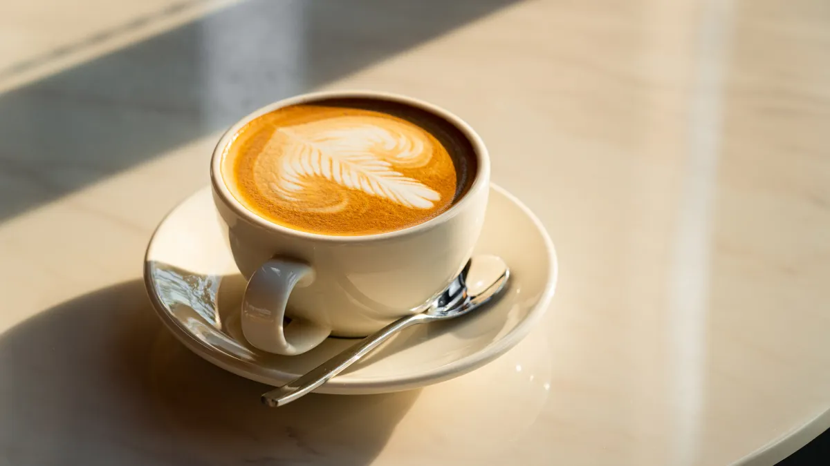 Feshly brewed latte coffee on a white table, a coffee drink made with espresso and steamed milk.