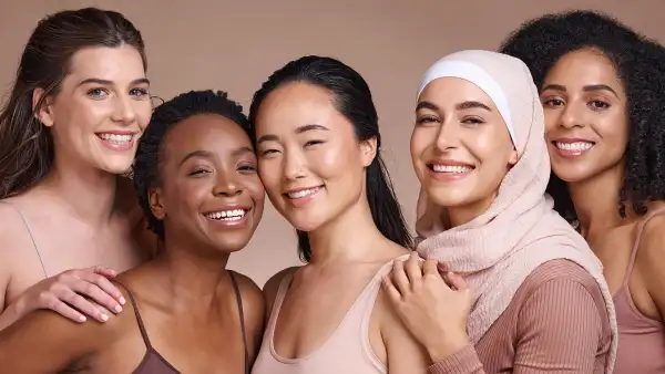 Diversity, women and beauty with skincare and portrait, smile and happy models, different and empowerment with motivation against studio background. Inclusion, equal and gender with culture and skin.