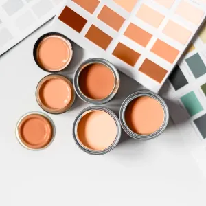 Tiny sample paint cans during house renovation, process of choosing paint for the walls, Peach Fuzz color of the year 2024, color charts on background