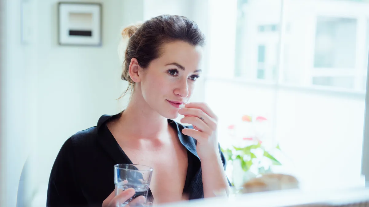 Woman taking vitamins and supplements.
