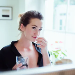Woman taking vitamins and supplements.